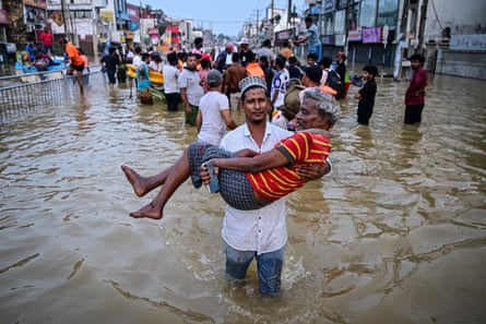 An elderly man is carried through a flooded street in Wellampitiya on the outskirts of Colombo, Sri Lanka, on Sunday.
