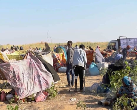Displaced Sudanese people gather in makeshift tents after fleeing Al-Fashir in Darfur