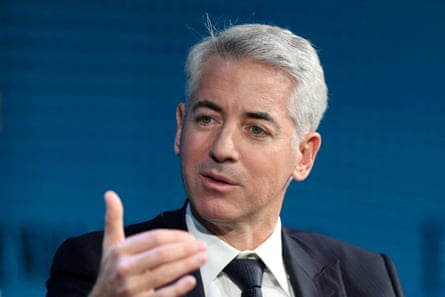 a white-haired man in a suit and tie speaks while gesturing