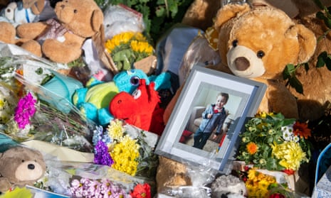 Floral tributes surround a photo of murdered five-year-old Logan Mwangi near where his body was found in Bridgend, Wales.