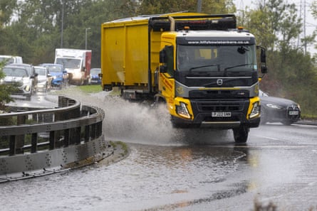 A truck driving through a flooded road.