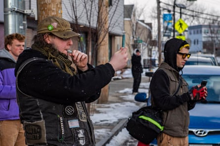 a man blows a whistle while recording video with his phone