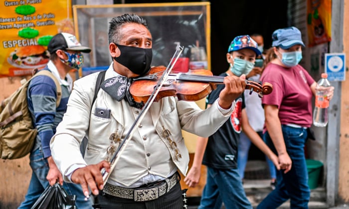 A Mariachi wears a face mask as he perform on the street to earn some money due to the lack of work amid the COVID-19 novel coronavirus pandemic, in Mexico City. Latin America and the Caribbean surpassed Europe on Friday to become the region hardest-hit by coronavirus deaths.