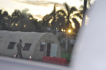 Two men in uniform walk beside large canvas tent