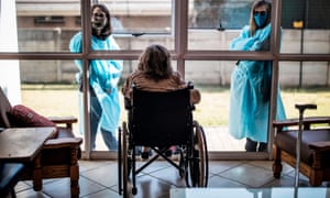 Relatives chat through a window to a resident of Casa Serena, a home for elderly people, in Johannesburg