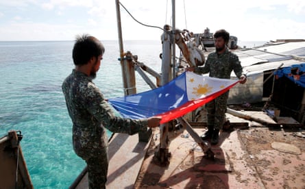 Philippine Marines fold their national flag aboard the BRP Sierra Madre in 2014