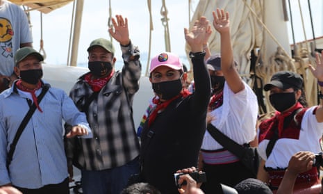 Members of the Zapatista Army of National Liberation (EZLN) wave goodbye as they set sail for Europe from Isla Mujeres, Mexico