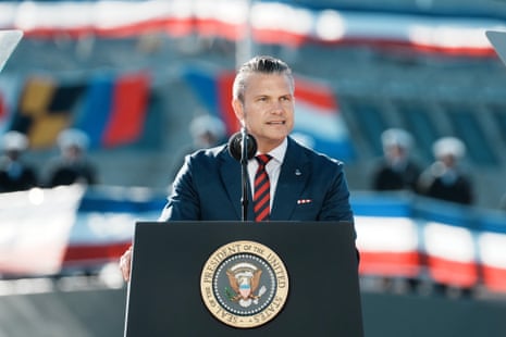 Pete Hegseth speaks at a presidential podium outdoors in a navy suit