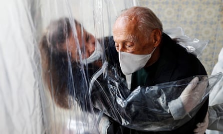 A woman hugs her father through a plastic curtain at a care home in São Paulo, Brazil.