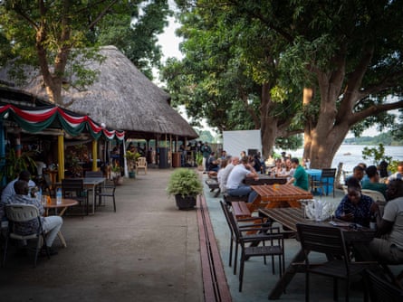 Afex River Camp is popular with international visitors, seen sitting outside at tables by the Nile 