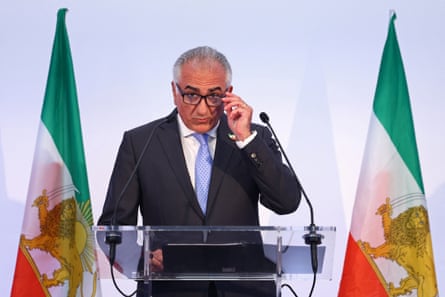 Pahlavi adjusting his glasses as he gives a speech