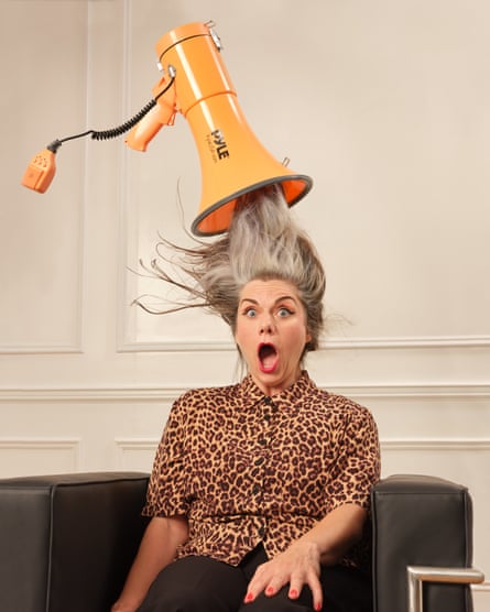 Portrait of Caitlin Moran sitting on a chair with her hair being sucked up into a megaphone