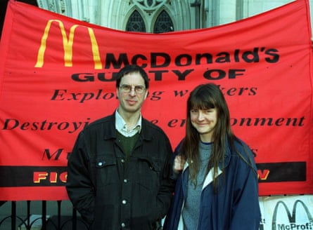 Morris and Steel standing in front of a red banner outside a court building