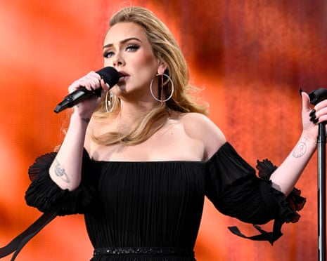 a woman in a black dress sings into a microphone