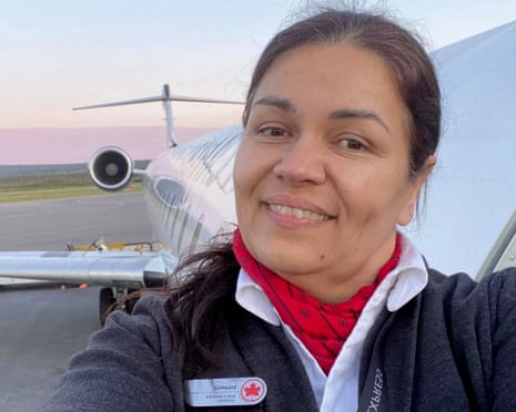woman in flight attendant uniform smiles in selfie outside of plane