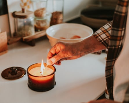 Woman lighting a candle at home