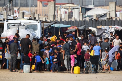 Displaced Palestinians queue for water from a truck next to their temporary camp in Rafah on Friday.