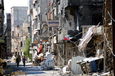 Soldiers walking through the demolished town of Tadamon in September 2013.