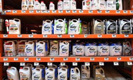 Prateleiras laranja contendo o produto Roundup.