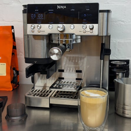 The Ninja Luxe Cafe Premier ES601 on a worktop next to a glass cup of coffee