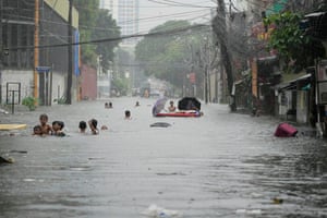 Children swim in floodwater after Tropical Storm Wipha caused intensified monsoon rains in Quezon