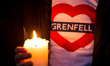 A candle is held during a silent march last year for those who died in the Grenfell Tower fire