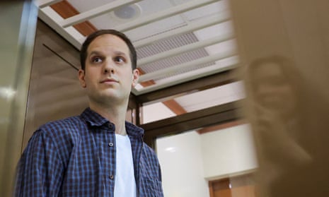 Evan Gershkovich stands in an enclosure for defendants before a court hearing in Moscow.