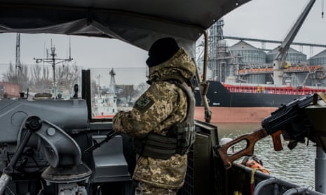 A Ukrainian sea border security force soldier guards Mariupol port on the Azov Sea.