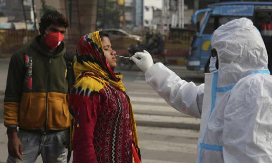 A health worker collects a swab sample from a woman