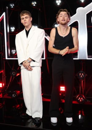 Australian singer Kid Laroi wears a sharp white zuitsuit, while US country singer Bailey Zimmerman looks distinctly more Australian in a singlet, mullet and goatee.