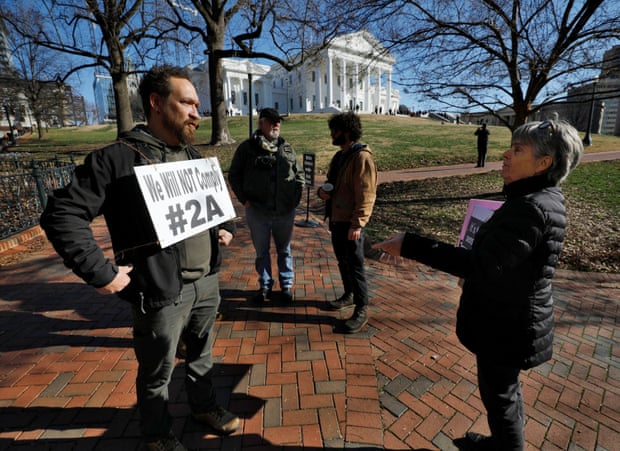 A gun rights activist, left, discusses the issue with a gun control proponent outside the Virginia state capitol building.