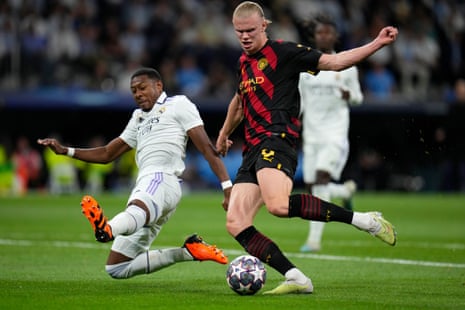 Real Madrid's David Alaba slides in to block a shot by Manchester City's Erling Haaland.