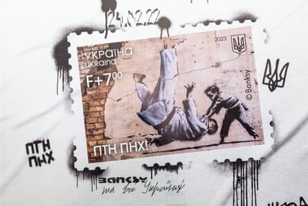 A billboard shows a stamp issued in Ukraine on the invasion’s first anniversary. It reads ‘FCK PTN!’, set against a Banksy mural on a ruined house in Borodyanka.