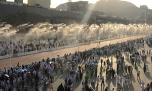 Pilgrims taking part in the Hajj in Mecca walk down a road with a water spray cooling system, part of an increasingly sophisticated support system required to beat the heat.