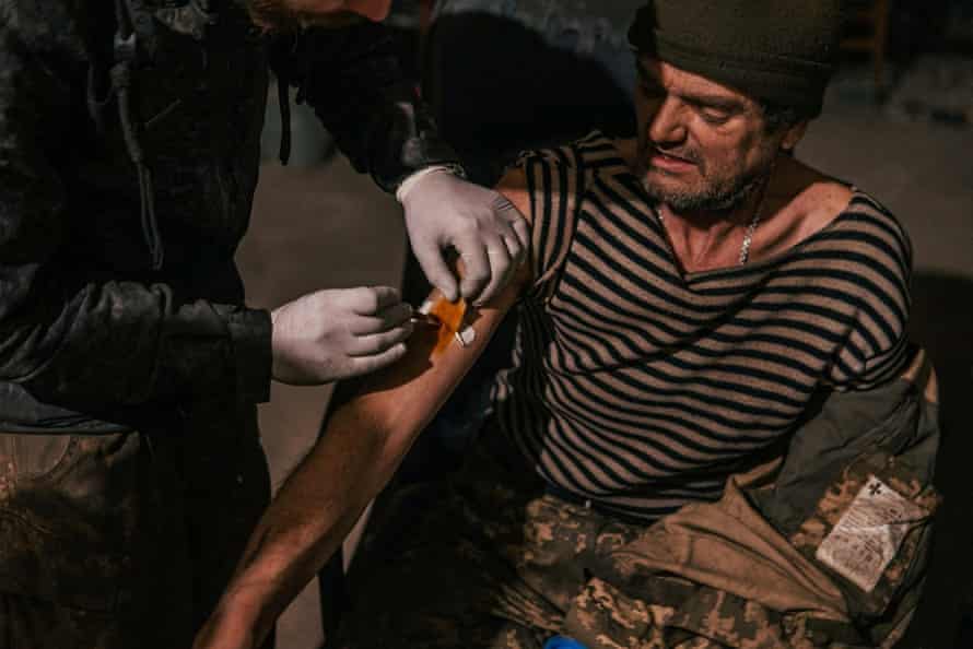 An injured Ukrainian work subordinate receives aesculapian assistance successful a tract infirmary wrong a bunker of the Azovstal plant.