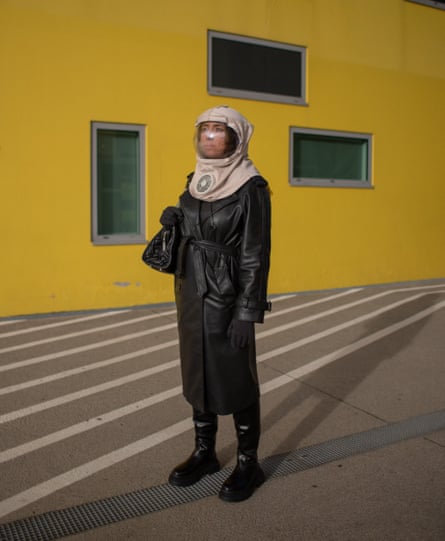 Nihal stood outside a yellow building in her helmet and trenchcoat