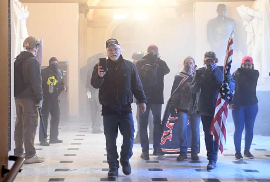 Supporters of Donald Trump enter the US Capitol as teargas fills the corridor.