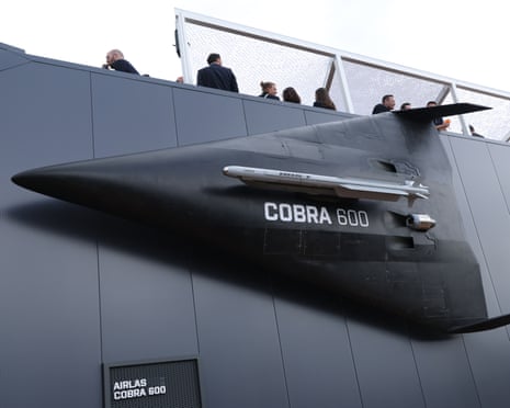 A dark grey interceptor drone labeled COBRA 600 with mounted missiles on display at an exhibition