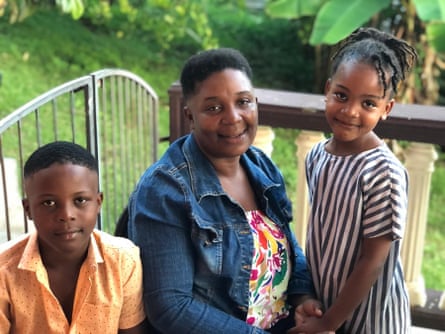 A woman and two children pose for a photo in a garden setting