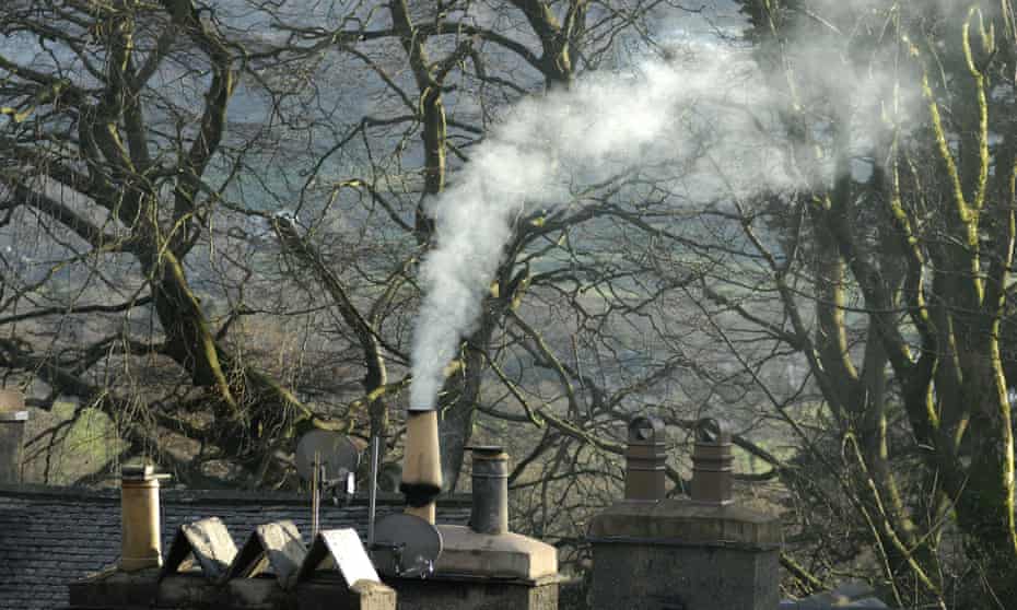 Smoke rises from a chimney on a house in Coniston, Cumbria, UK