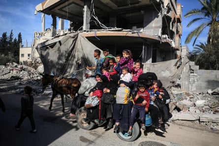 People leaving the Maghazi refugee camp with their belongings in the central Gaza Strip, on 8 January 2024