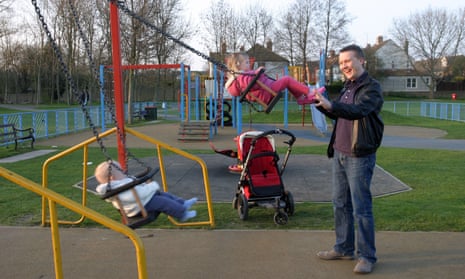A father playing with children in the park.
