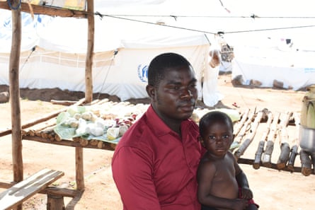 An African man with his young son on his lap.