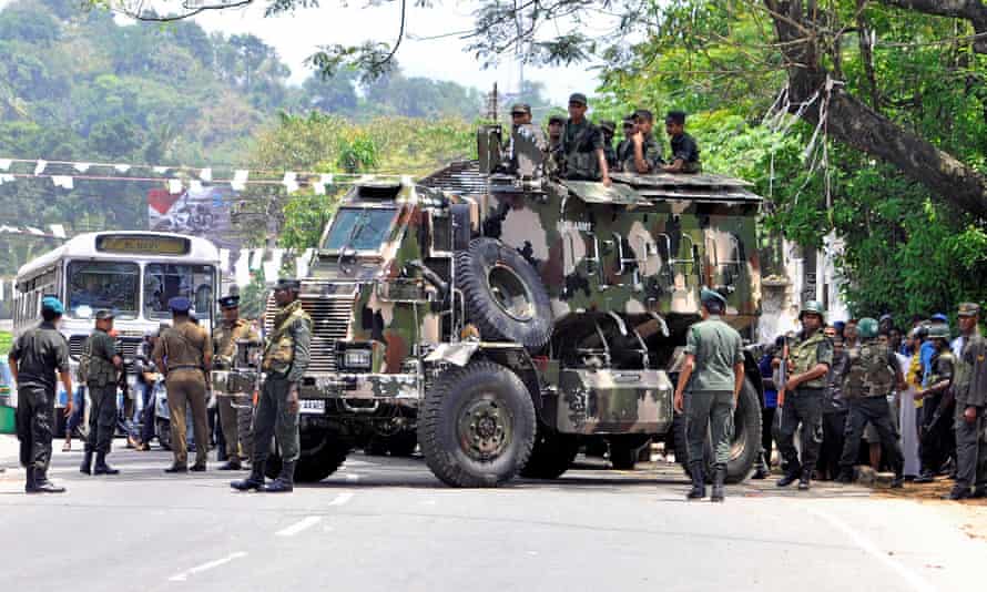 Sri Lanka’s army soldiers stand guard a road after clashes.