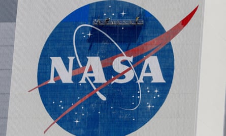 Workers pressure wash the logo of Nasa on the Vehicle Assembly Building.