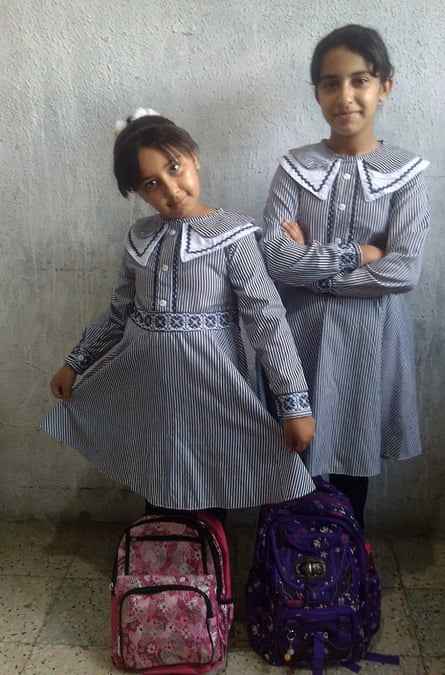 Lulu al-Ghussain and her elder sister standing in matching button dresses