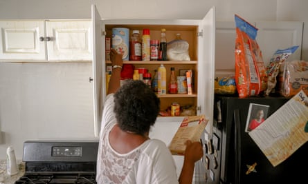 a woman reaches for items in her kitchen