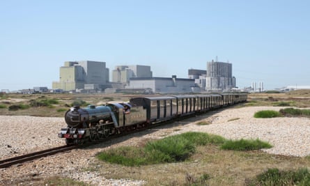A steam train on the Romney, Hythe and Dymchurch Railway heads east from Dungeness, with the Dungeness A & B nuclear power stations in the background.2ARD14T A steam train on the Romney, Hythe and Dymchurch Railway heads east from Dungeness, with the Dungeness A & B nuclear power stations in the background.