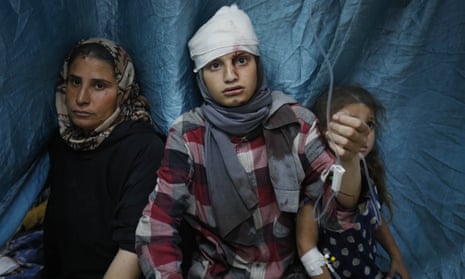Palestinians including children, injured in Israeli attacks at Nuseirat refugee camp, are treated at al-Aqsa Martyrs hospital in Deir al-Balah, Gaza on Saturday.