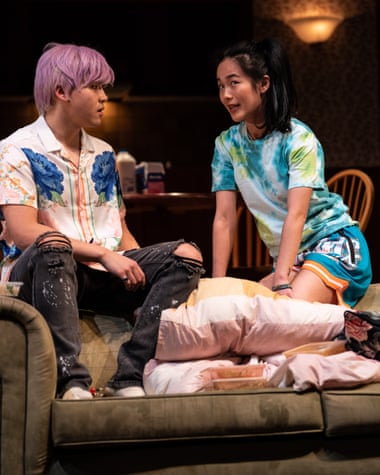 Jeffrey Liu and Susanna Qian seated on the back of a sofa on stage